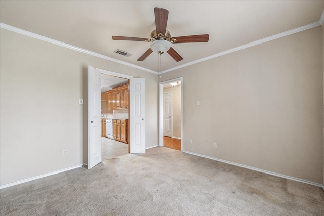 spare room featuring ceiling fan, light carpet, and ornamental molding