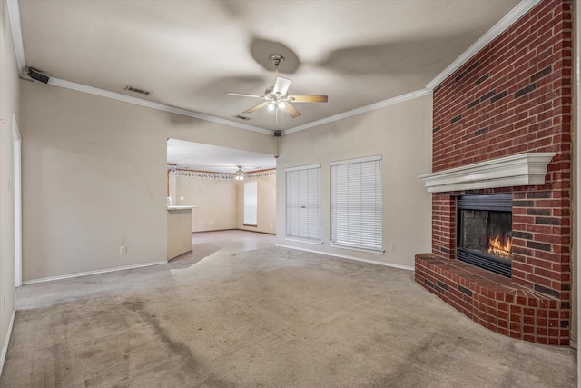 unfurnished living room with light carpet, a brick fireplace, crown molding, and ceiling fan