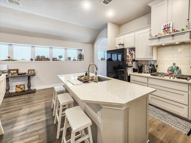 kitchen with a center island with sink, sink, and a breakfast bar area