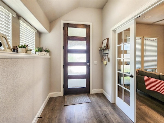 foyer featuring lofted ceiling, wood-type flooring, a wealth of natural light, and french doors