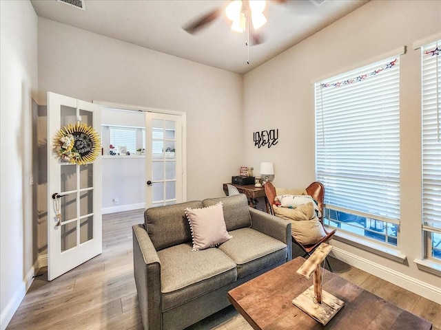 living room with ceiling fan, light wood-type flooring, and french doors