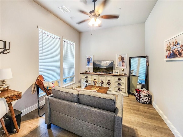 living room featuring wood-type flooring, plenty of natural light, and ceiling fan