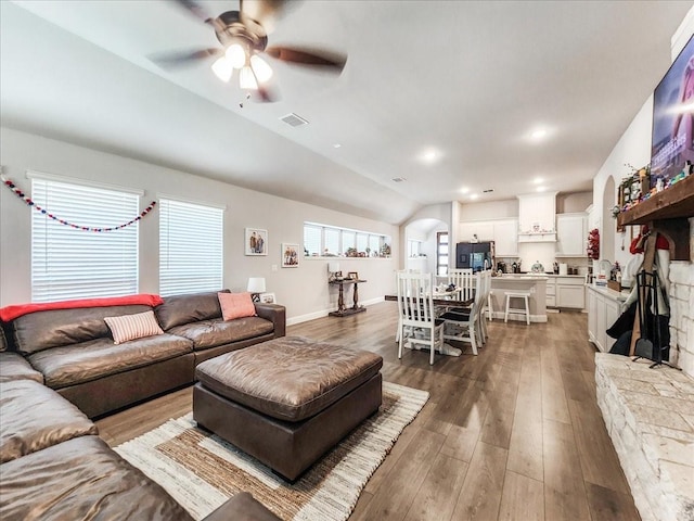 living room with ceiling fan, dark hardwood / wood-style flooring, and lofted ceiling