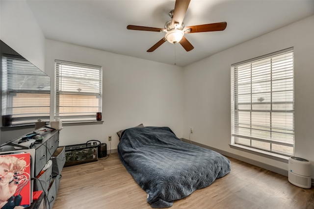 bedroom featuring multiple windows, light wood-type flooring, and ceiling fan