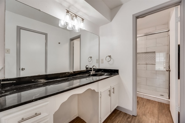 bathroom featuring an inviting chandelier, vanity, an enclosed shower, and wood-type flooring