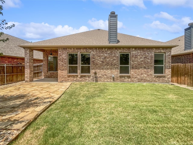 rear view of property featuring a patio area and a lawn