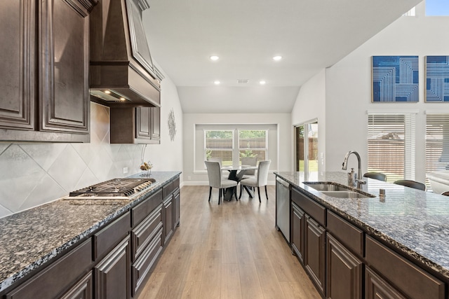 kitchen with light hardwood / wood-style flooring, tasteful backsplash, vaulted ceiling, sink, and custom range hood