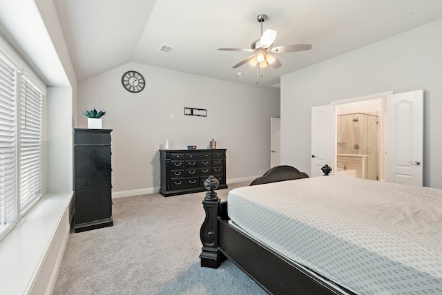 carpeted bedroom with vaulted ceiling, multiple windows, ensuite bath, and ceiling fan