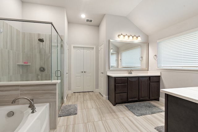 bathroom featuring vanity, separate shower and tub, lofted ceiling, and tile patterned flooring