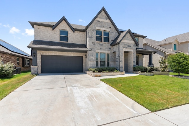 view of front facade with a garage, solar panels, cooling unit, and a front yard