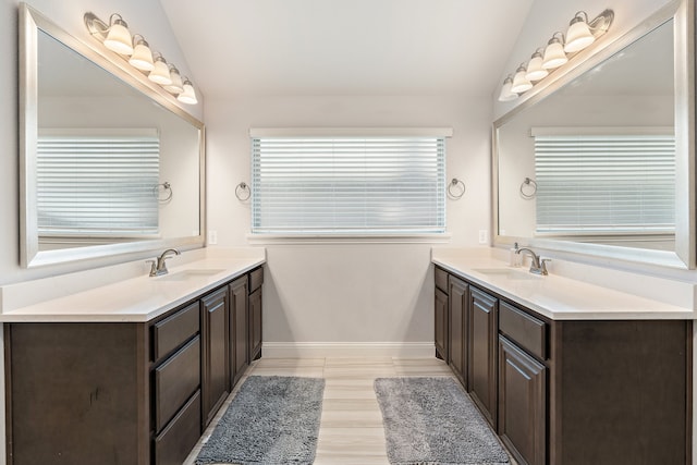 bathroom with lofted ceiling and dual bowl vanity