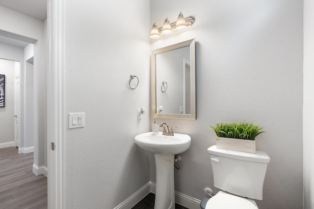 bathroom with toilet and wood-type flooring