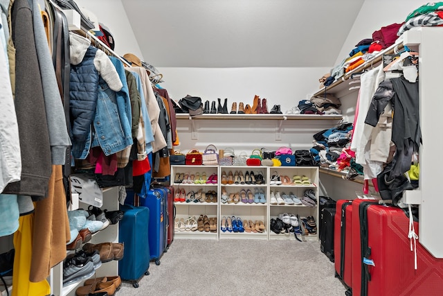 walk in closet featuring lofted ceiling and carpet floors