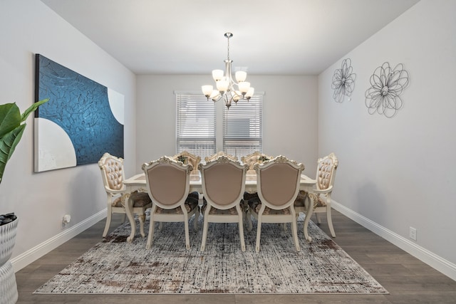 dining room with dark wood-type flooring and a notable chandelier