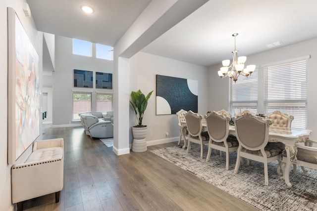 dining space with dark hardwood / wood-style floors and a notable chandelier