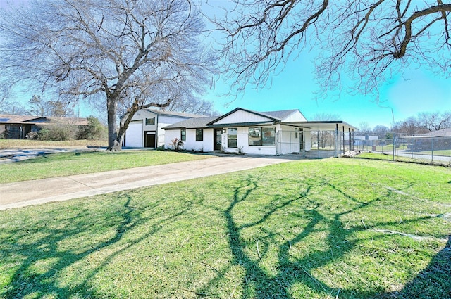 view of front of property with fence, concrete driveway, and a front yard