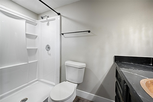 full bath featuring a stall shower, wood finished floors, toilet, and baseboards