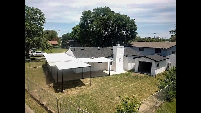 exterior space featuring a patio, a lawn, a chimney, and fence