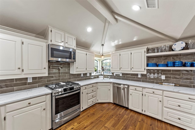 kitchen featuring lofted ceiling with beams, white cabinetry, and appliances with stainless steel finishes