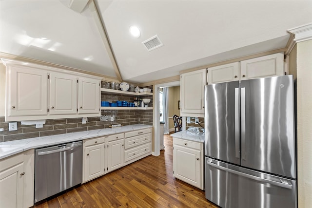 kitchen with stainless steel appliances, vaulted ceiling, white cabinetry, and light stone counters