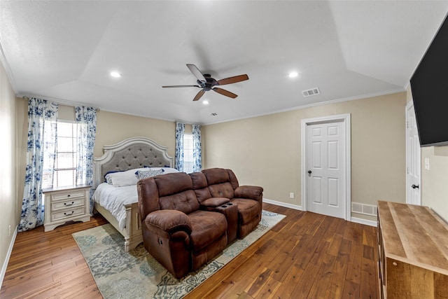 bedroom featuring multiple windows, light hardwood / wood-style flooring, ceiling fan, and crown molding