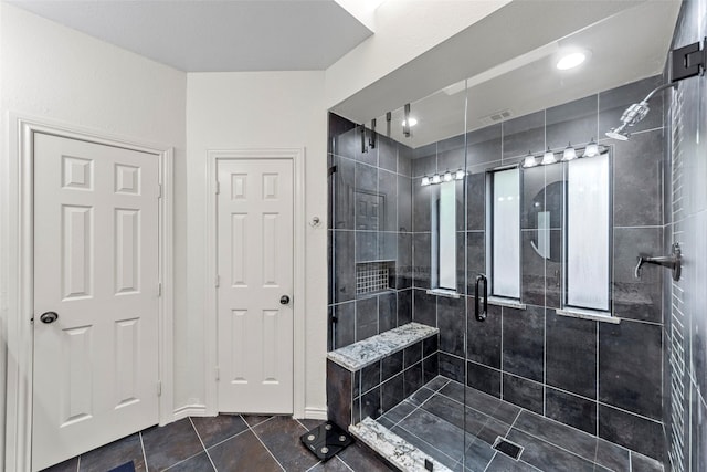 bathroom with tile patterned floors and a shower with door