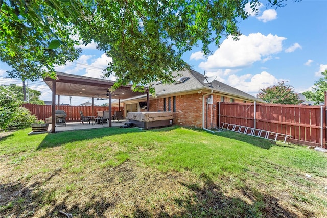 view of yard featuring ceiling fan, a patio, and a hot tub