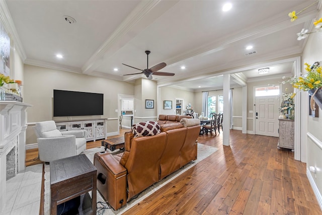 living room featuring beam ceiling, hardwood / wood-style flooring, ceiling fan, and ornamental molding