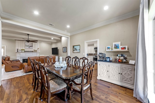 dining space with hardwood / wood-style flooring, ceiling fan, and ornamental molding