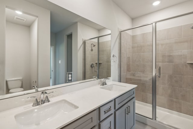 bathroom with toilet, vanity, and an enclosed shower