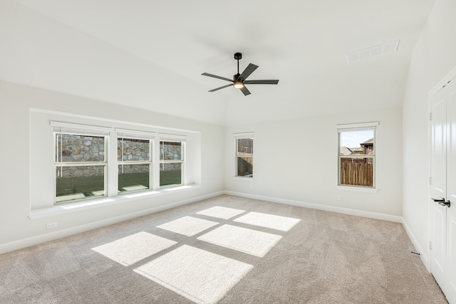 carpeted empty room with high vaulted ceiling, a healthy amount of sunlight, and ceiling fan