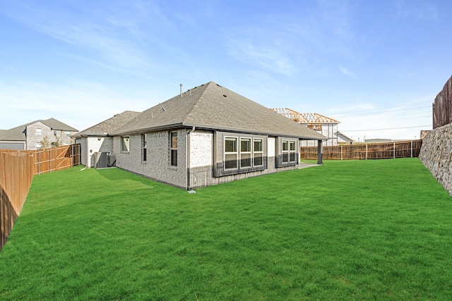 back of house with cooling unit and a lawn