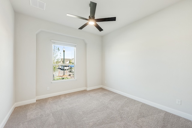 spare room with ceiling fan and carpet