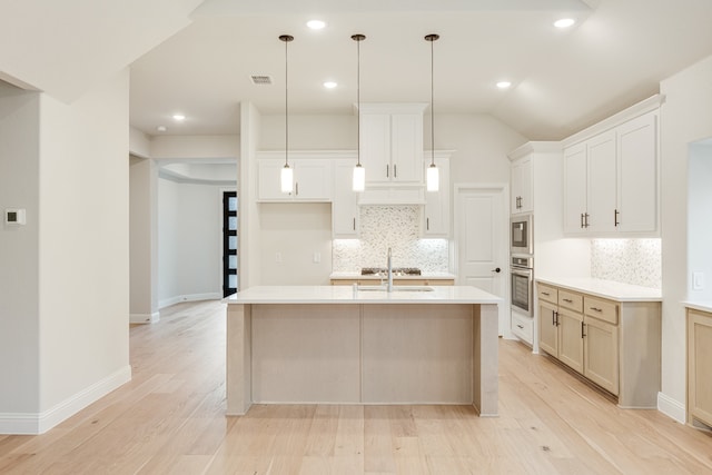 kitchen with a center island with sink, white cabinetry, appliances with stainless steel finishes, and light hardwood / wood-style flooring