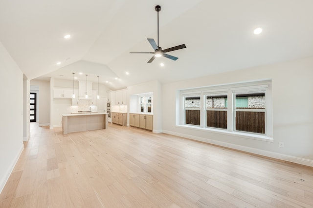 unfurnished living room with vaulted ceiling, light hardwood / wood-style flooring, and ceiling fan