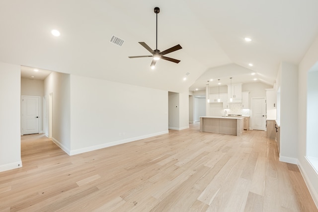 unfurnished living room with ceiling fan, light hardwood / wood-style floors, and vaulted ceiling