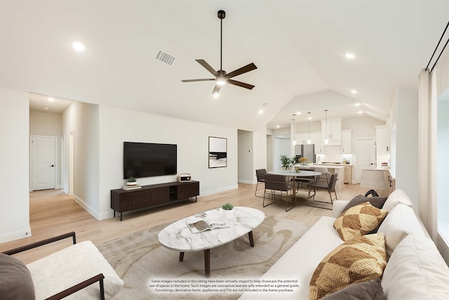 living room with ceiling fan, light hardwood / wood-style flooring, and lofted ceiling