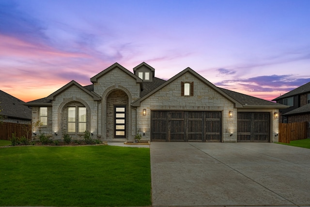 french provincial home featuring a yard and a garage