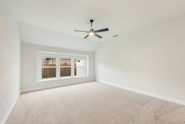 unfurnished room with light carpet, ceiling fan, and vaulted ceiling