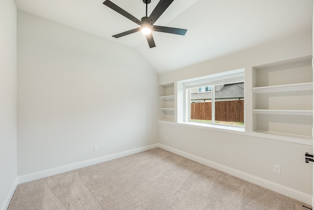 carpeted empty room with ceiling fan and vaulted ceiling