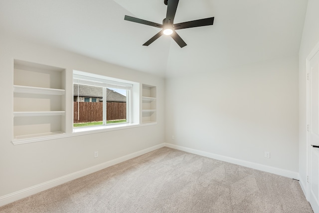 carpeted empty room with ceiling fan and built in features