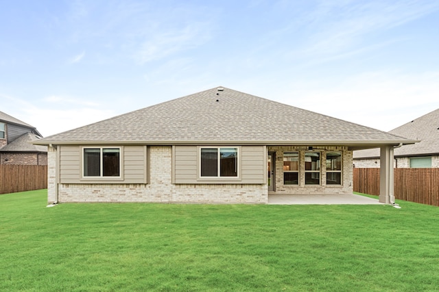 rear view of property featuring a lawn and a patio