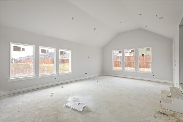 empty room featuring lofted ceiling and a healthy amount of sunlight