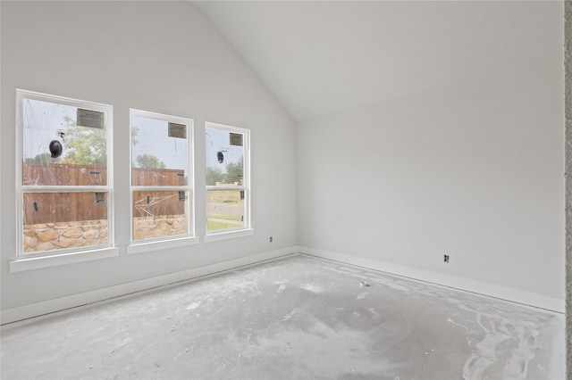 spare room with lofted ceiling and concrete floors