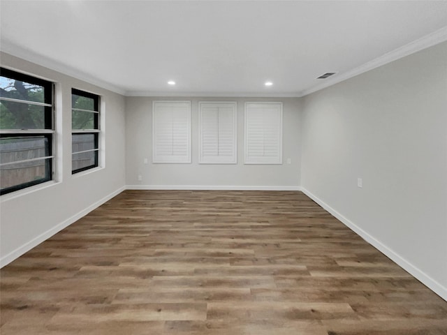 spare room featuring wood-type flooring and crown molding