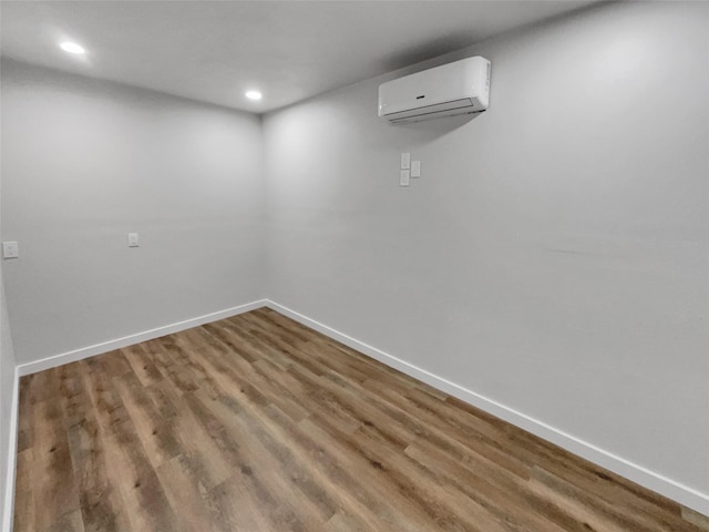 unfurnished room with wood-type flooring and a wall mounted AC