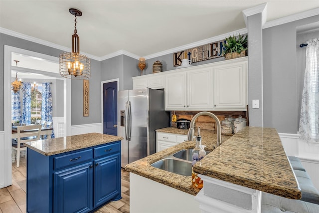 kitchen featuring stainless steel fridge, blue cabinetry, an inviting chandelier, white cabinets, and hanging light fixtures