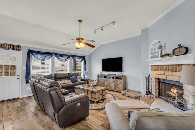 living room featuring crown molding, light wood finished floors, a ceiling fan, and lofted ceiling