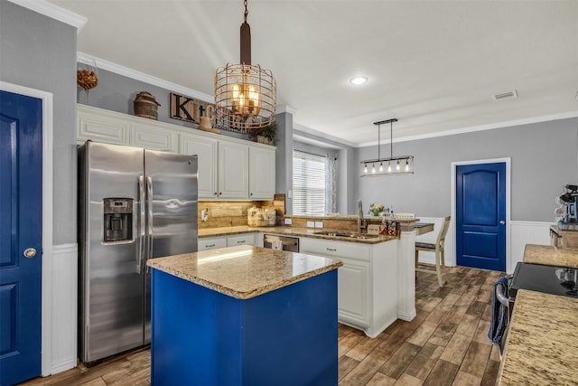kitchen with an inviting chandelier, ornamental molding, visible vents, a sink, and stainless steel appliances