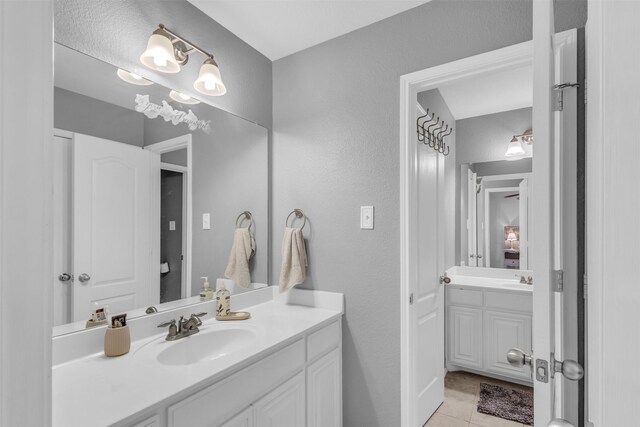 bathroom with tile patterned floors, vanity, and an inviting chandelier